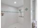 Bright shower room with white tile and light teal diamond accents, plus a shower grab bar at 5473 Blue Heron Ln, Wesley Chapel, FL 33543