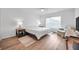 Bright bedroom with wood floors, white walls, and a comfortable sitting area next to the window at 5473 Blue Heron Ln, Wesley Chapel, FL 33543