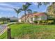 Well-maintained lawn and landscaping with palm trees that surround this white home at 5473 Blue Heron Ln, Wesley Chapel, FL 33543