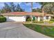 Charming single-story home with a tile roof, beautiful landscaping, and a two-car garage at 5473 Blue Heron Ln, Wesley Chapel, FL 33543