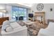 Comfortable living room with sliding doors leading to outdoor seating, and features a fireplace with mantle at 5473 Blue Heron Ln, Wesley Chapel, FL 33543