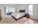 Bright main bedroom with king bed, wood floors, and sliding glass doors to lanai offering ample natural light at 5473 Blue Heron Ln, Wesley Chapel, FL 33543