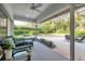 Enclosed patio with seating area, a ceiling fan, and a view of the landscaped backyard at 5473 Blue Heron Ln, Wesley Chapel, FL 33543