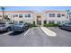 Condominium exterior shows ample parking in front of a well-maintained building with lush landscaping at 6061 Bahia Del Mar Blvd # 112, St Petersburg, FL 33715