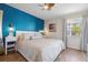 Charming bedroom with a calming blue accent wall, wood flooring, and a ceiling fan, creating a serene retreat at 6915 Stones Throw N Cir # 3104, St Petersburg, FL 33710