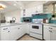 Bright kitchen with white cabinets, stainless steel appliances, and stylish backsplash at 6915 Stones Throw N Cir # 3104, St Petersburg, FL 33710