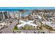 Aerial view of condo complex, showcasing the building's unique X shape and surrounding landscape and parking at 7050 Sunset Way # 26, St Pete Beach, FL 33706