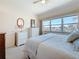 Inviting bedroom with a plush bed, plenty of dresser storage, and an external view from the window at 7050 Sunset Way # 26, St Pete Beach, FL 33706