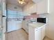 Cozy kitchen featuring white cabinetry, a tiled backsplash, and essential appliances, ready for meal preparation at 7050 Sunset Way # 26, St Pete Beach, FL 33706