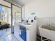 Shared laundry room with two white washing machines and a utility sink at 7050 Sunset Way # 26, St Pete Beach, FL 33706
