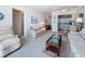 Cozy living room features comfortable seating and an open floor plan flowing into the kitchen area at 7050 Sunset Way # 26, St Pete Beach, FL 33706