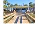 Exterior view of a beachside restaurant with open-air dining and a wooden walkway at 7050 Sunset Way # 26, St Pete Beach, FL 33706