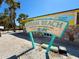 Upham Beach sign with nearby tropical palm trees on a sunny day at 7050 Sunset Way # 26, St Pete Beach, FL 33706