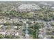 An aerial view showcases a peaceful neighborhood mixed with tree-lined streets and a winding pond at 7314 Princeton Dr, Hudson, FL 34667