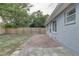 View of the backyard with the house, brick patio, and fenced perimeter at 7314 Princeton Dr, Hudson, FL 34667