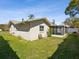 Backyard with a screen porch and flourishing green lawn at 803 Helmsman Way, Palm Harbor, FL 34685