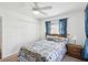 Comfortable bedroom featuring a ceiling fan, closet, and a window with charming blue curtains at 803 Helmsman Way, Palm Harbor, FL 34685