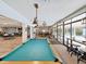 Spacious game room featuring a pool table, seating, and large windows overlooking the community at 803 Helmsman Way, Palm Harbor, FL 34685