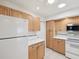 Bright kitchen featuring all white appliances, wood cabinetry, and tile flooring at 803 Helmsman Way, Palm Harbor, FL 34685