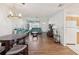Open-concept room showcasing wood floors, a modern light fixture, and kitchen access at 803 Helmsman Way, Palm Harbor, FL 34685