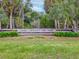 John Chesnut Sr. Park entrance sign, framed by lush greenery and tall trees, welcoming visitors at 803 Helmsman Way, Palm Harbor, FL 34685