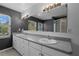 Bathroom with double sinks, vanity, and a large mirror, with large windows at 914 Woodbridge Ct, Safety Harbor, FL 34695