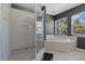 Bathroom featuring a glass enclosed shower and separate soaking tub at 914 Woodbridge Ct, Safety Harbor, FL 34695