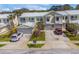 Townhomes with attached garages and brick driveways under a blue sky at 914 Woodbridge Ct, Safety Harbor, FL 34695