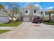 Well-maintained townhome featuring attached garages, a brick paver driveway, and lush landscaping at 914 Woodbridge Ct, Safety Harbor, FL 34695