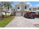 Townhome with an attached garage, lush landscaping, and a brick driveway at 914 Woodbridge Ct, Safety Harbor, FL 34695