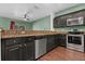 Kitchen featuring stainless steel appliances, dark cabinets, granite countertops, and a ceiling fan at 914 Woodbridge Ct, Safety Harbor, FL 34695