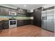 Stylish kitchen featuring stainless steel appliances, dark cabinetry, and granite countertops, perfect for culinary enthusiasts at 914 Woodbridge Ct, Safety Harbor, FL 34695
