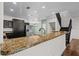 Kitchen with a breakfast bar featuring granite countertops, stainless steel appliances, and dark cabinets at 914 Woodbridge Ct, Safety Harbor, FL 34695