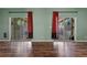 Living room features sliding glass doors with red drapes and beautiful hardwood floors at 914 Woodbridge Ct, Safety Harbor, FL 34695
