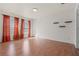 Bright, spacious living room with wood floors, natural light from two windows, and minimalist floating shelves at 914 Woodbridge Ct, Safety Harbor, FL 34695