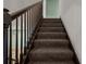 Close up of carpeted stairs featuring dark wood banister at 914 Woodbridge Ct, Safety Harbor, FL 34695