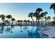 Inviting community pool surrounded by lush palm trees and relaxing lounge chairs at 100 Bluff View Dr # 417A, Belleair Bluffs, FL 33770