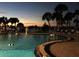Inviting pool area with tropical palm trees and a colorful sunset backdrop at 100 Bluff View Dr # 417A, Belleair Bluffs, FL 33770