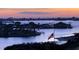 Beautiful scenic water view featuring islands, homes, and an American flag at dusk at 100 Bluff View Dr # 417A, Belleair Bluffs, FL 33770