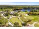 Aerial view of the golf course and lake offering a scenic view of the golf, club house, and water features at 10561 Greencrest Dr, Tampa, FL 33626