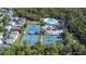 Aerial view of the community pool, tennis courts, parking, and nearby homes surrounded by green trees at 10561 Greencrest Dr, Tampa, FL 33626
