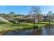 View of a home's backyard including a screened in portion, lawn, and view of the pond at 10561 Greencrest Dr, Tampa, FL 33626