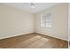 Bright bedroom featuring wood floors, a ceiling fan, and a window with light-filtering shutters at 10561 Greencrest Dr, Tampa, FL 33626