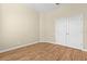 Bedroom with hardwood floors, cream walls, and closet with bifold doors at 10561 Greencrest Dr, Tampa, FL 33626