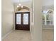 Welcoming foyer featuring elegant tile flooring, decorative double doors, and a stylish chandelier at 10561 Greencrest Dr, Tampa, FL 33626