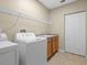 Functional laundry room featuring a utility sink, storage cabinets, and shelving for efficient organization at 10561 Greencrest Dr, Tampa, FL 33626
