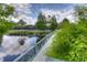 Scenic view of a pond and walking bridge with lush landscaping and a tennis court in the background at 10561 Greencrest Dr, Tampa, FL 33626