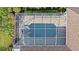 Aerial view of a screened-in pool and spa surrounded by a patio and lush landscaping at 10561 Greencrest Dr, Tampa, FL 33626