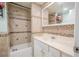 Well-lit bathroom featuring a tub with shower, mosaic tile accents, and a vanity with storage at 12303 Greenland Dr, Riverview, FL 33579