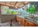 Exterior kitchen with stainless steel sink and a view of trees at 12303 Greenland Dr, Riverview, FL 33579